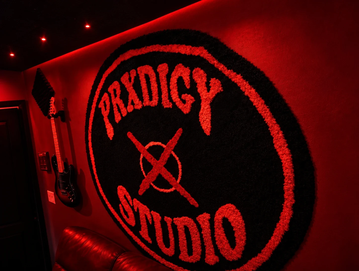 PRXDIGY Studio stamp on the red wall of the Long Island room